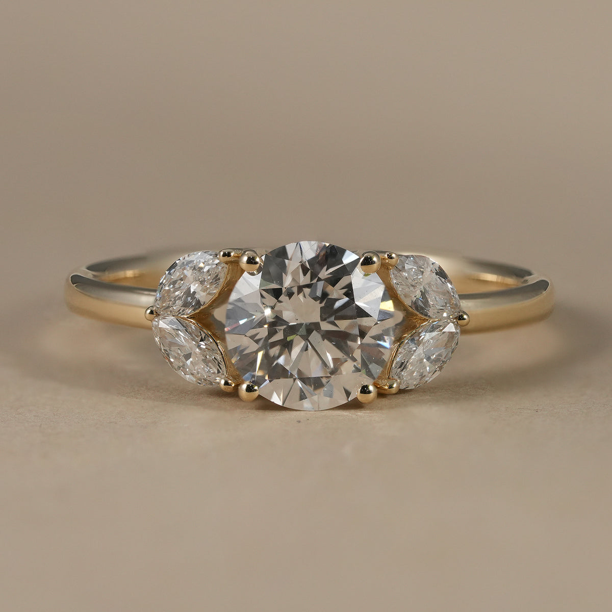 Round lab grown diamond floral cluster engagement ring with marquise diamond side accents.