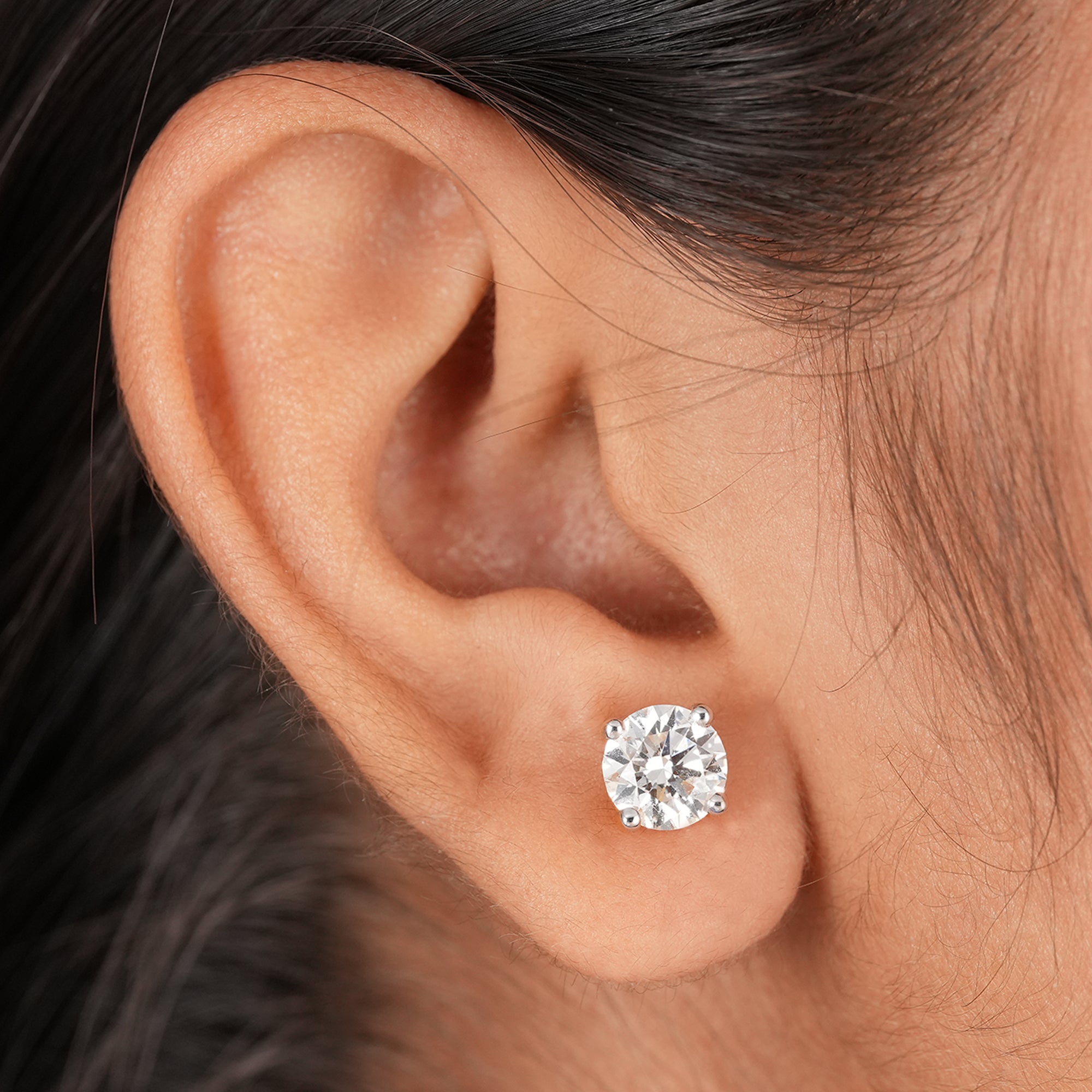 Four prong round diamond stud earrings close up