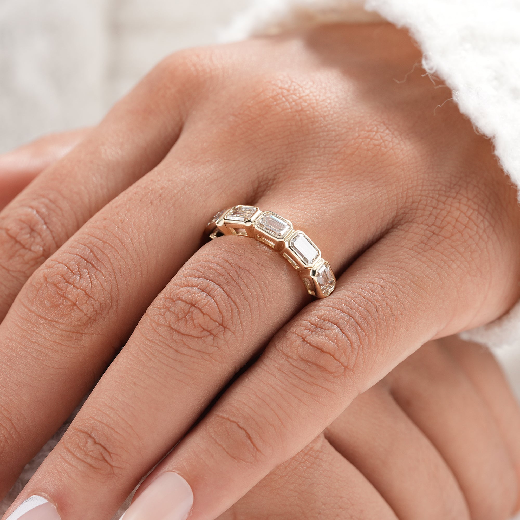 Gold emerald cut five stone lab grown diamond ring.