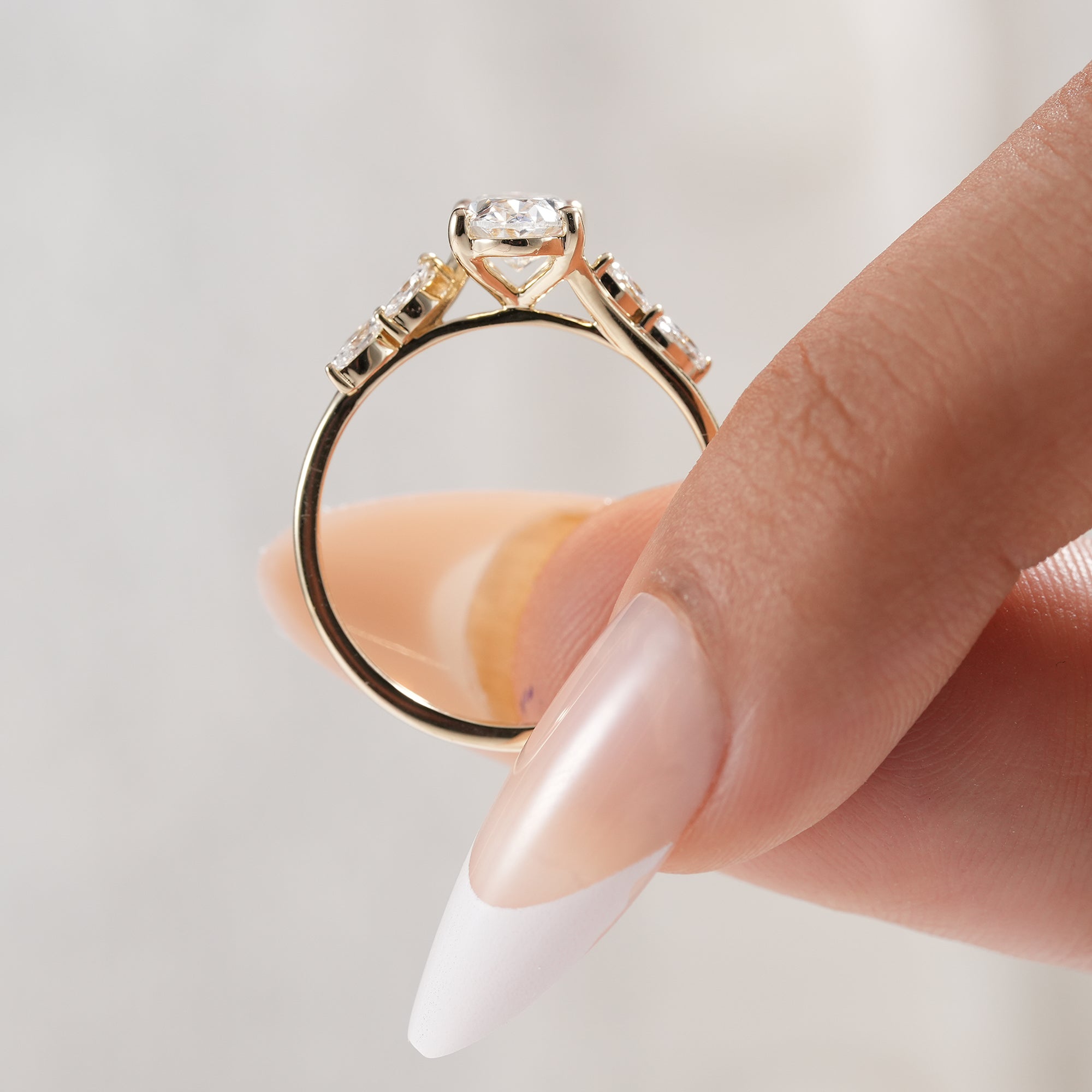 Modern oval diamond bridal ring with elegant leaf design.