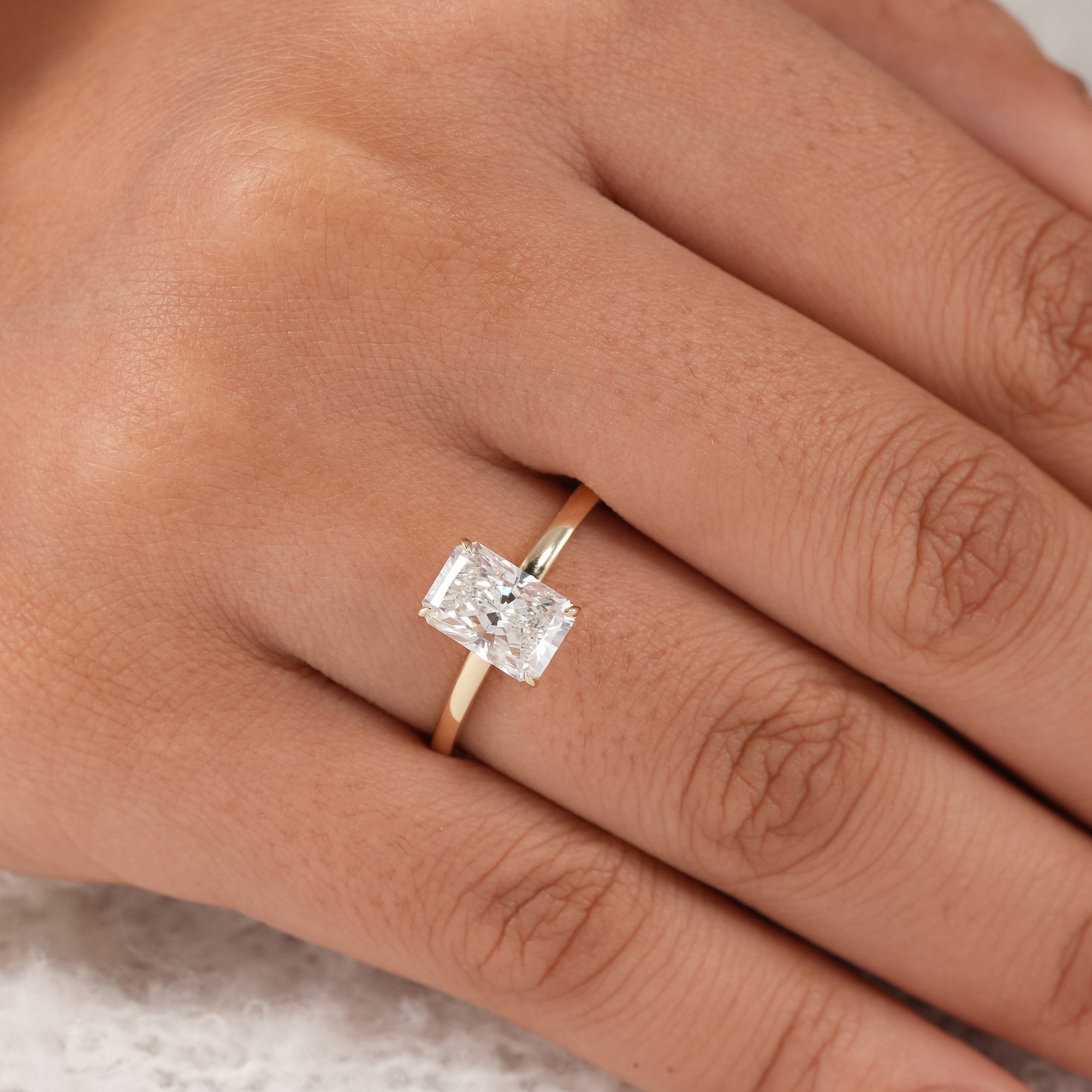 Luxury radiant solitaire ring with slim gold band.