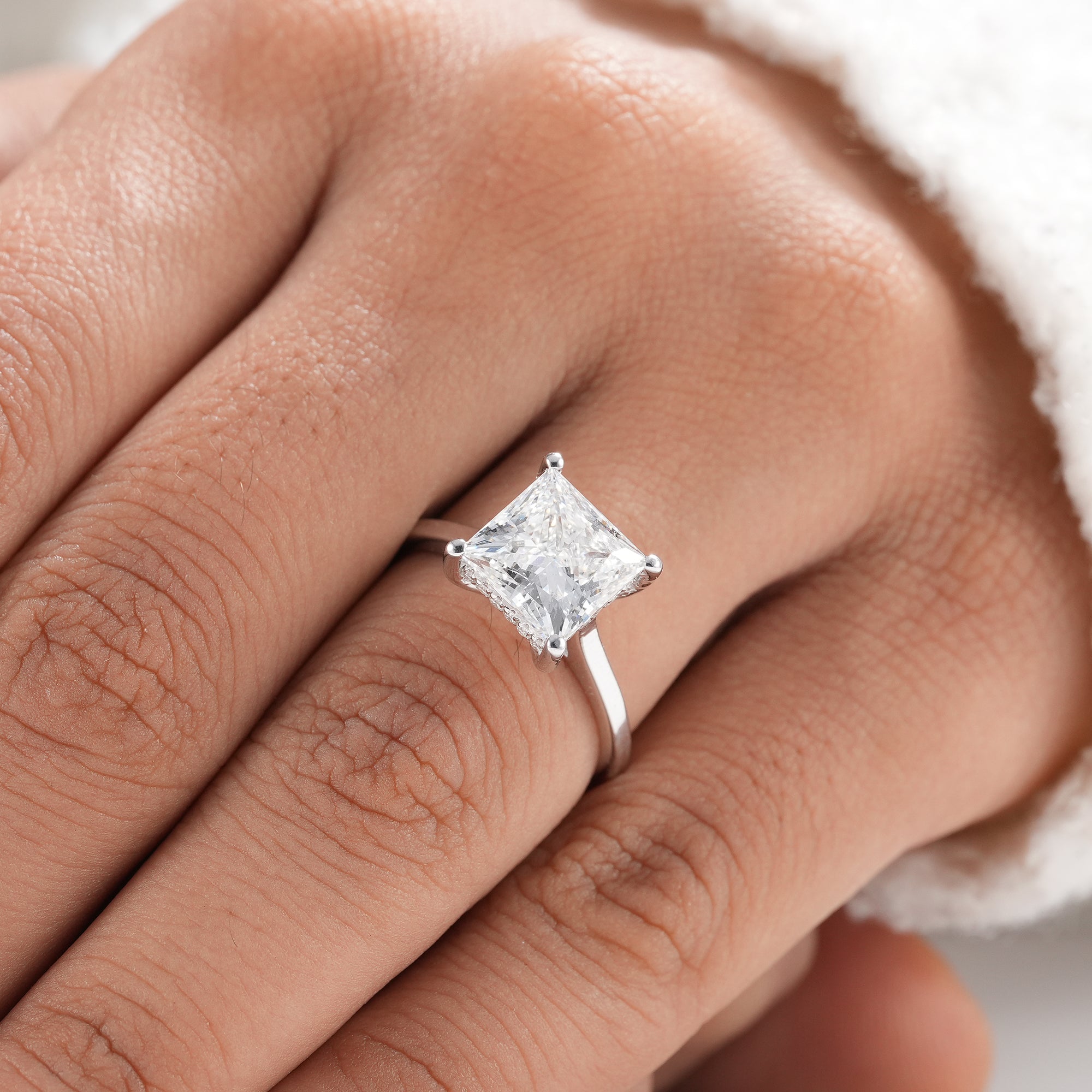 Bridal princess diamond ring with hidden halo design.