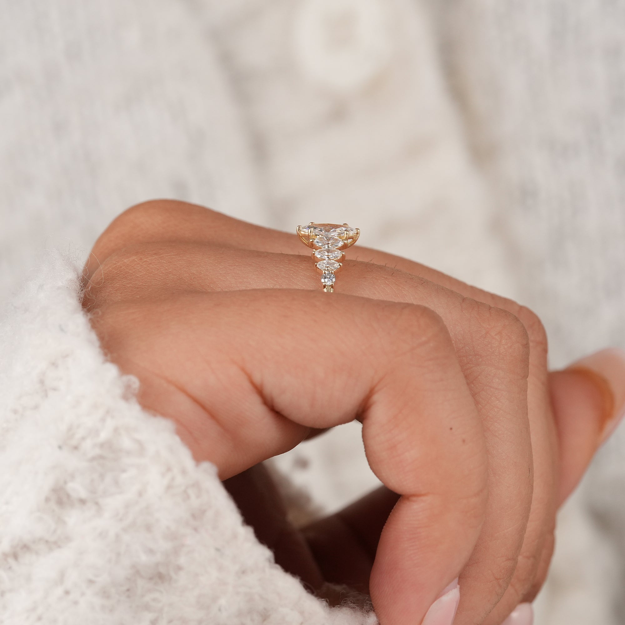 Gold marquise engagement ring with round accent diamonds.
