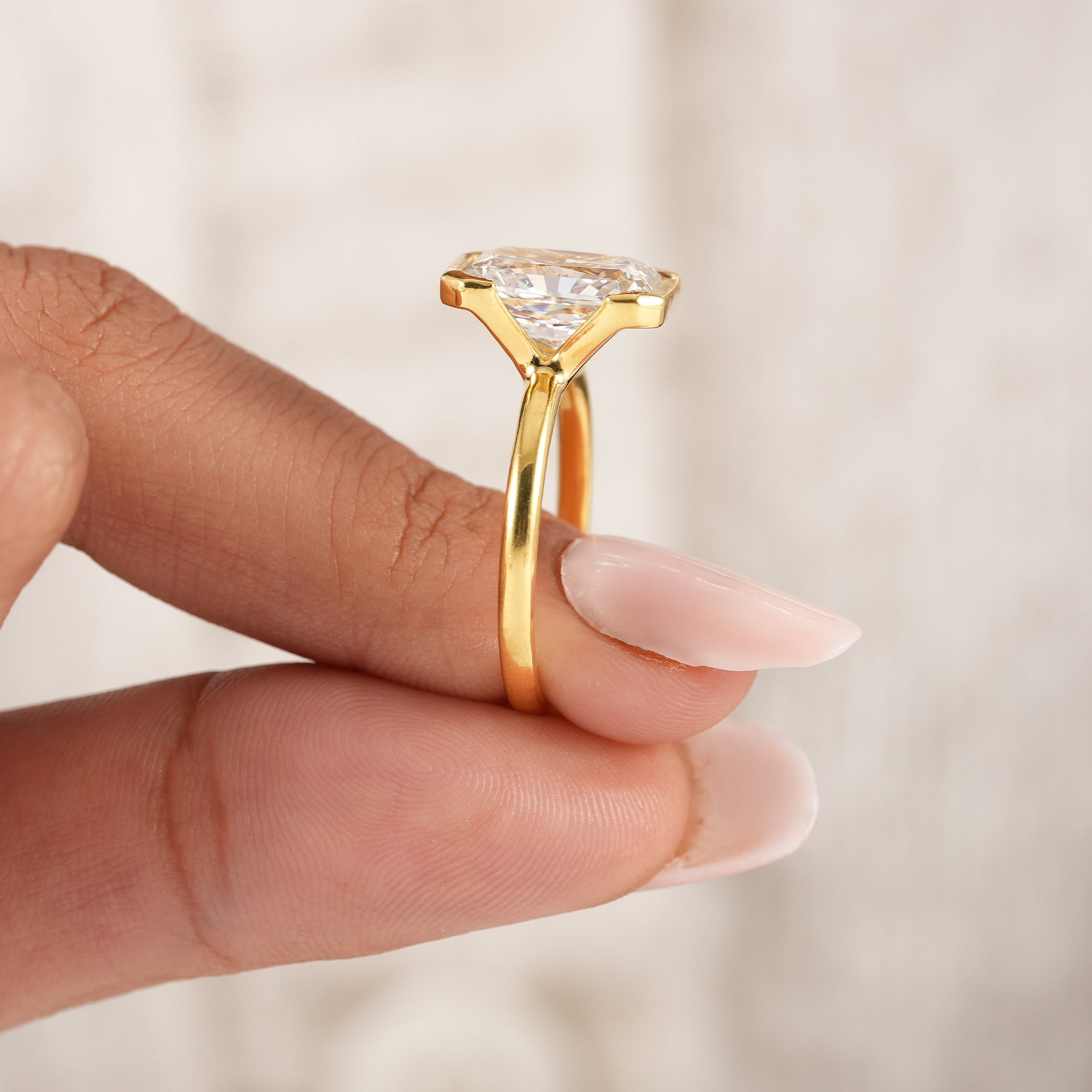 Ethical radiant cut engagement ring with half bezel setting.