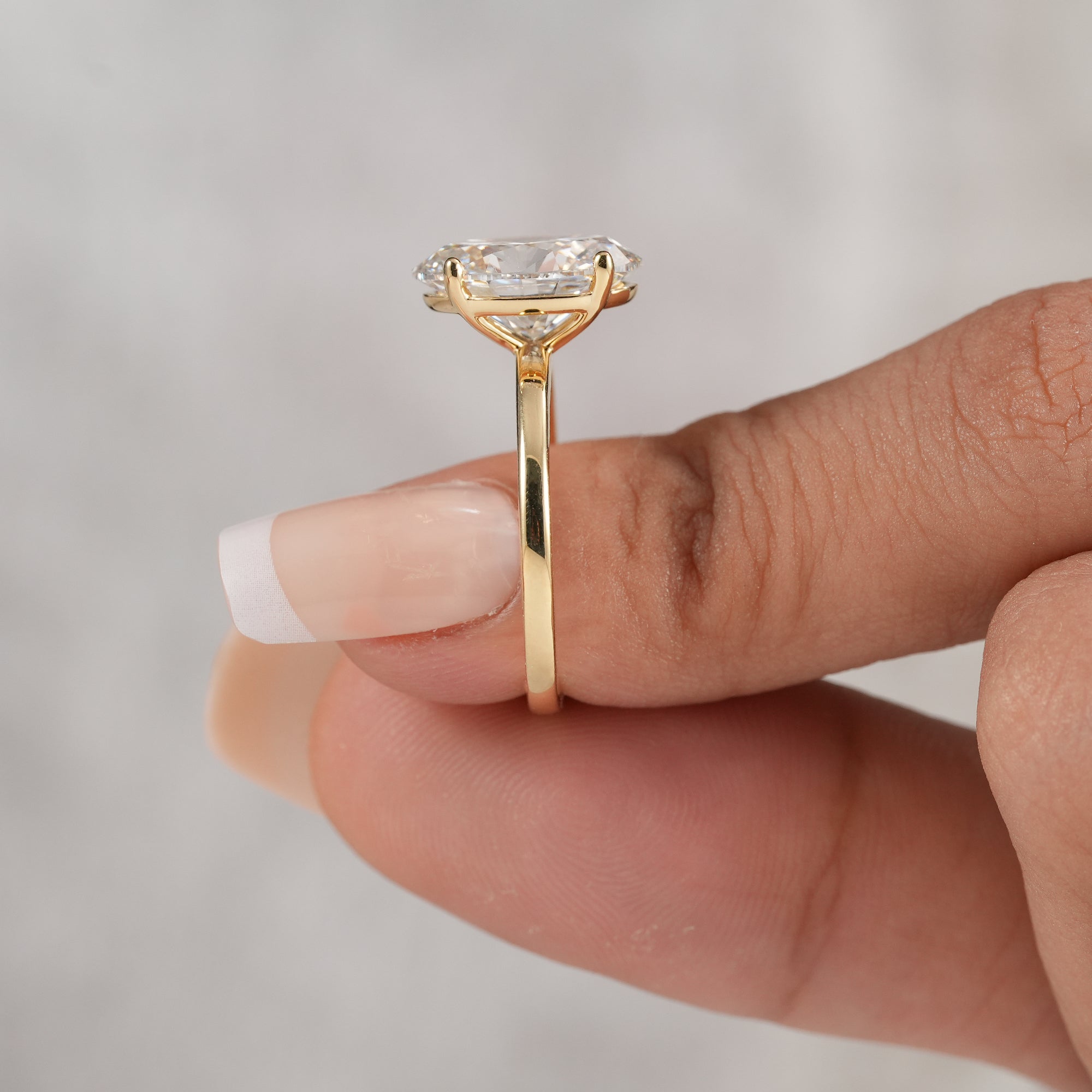Yellow gold oval lab grown diamond engagement ring.