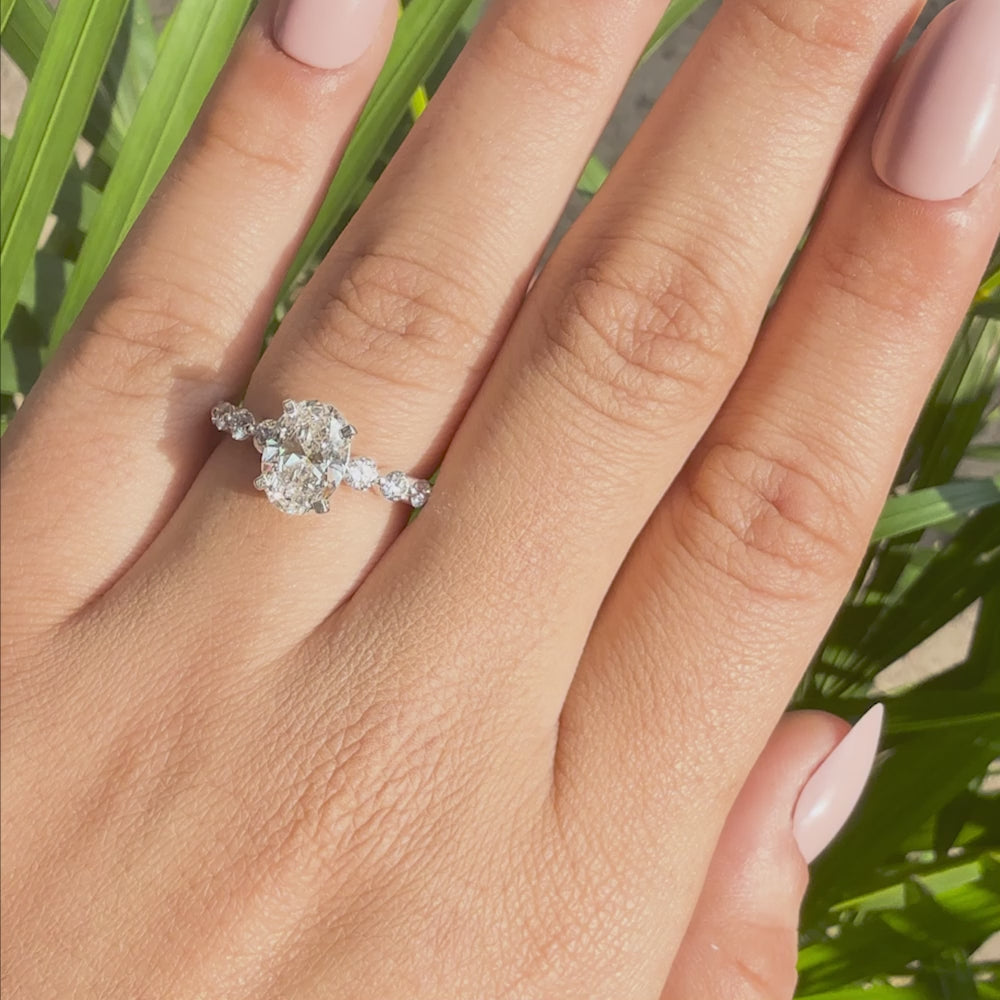 Oval cut lab grown diamond ring featuring a sparkling side stone band