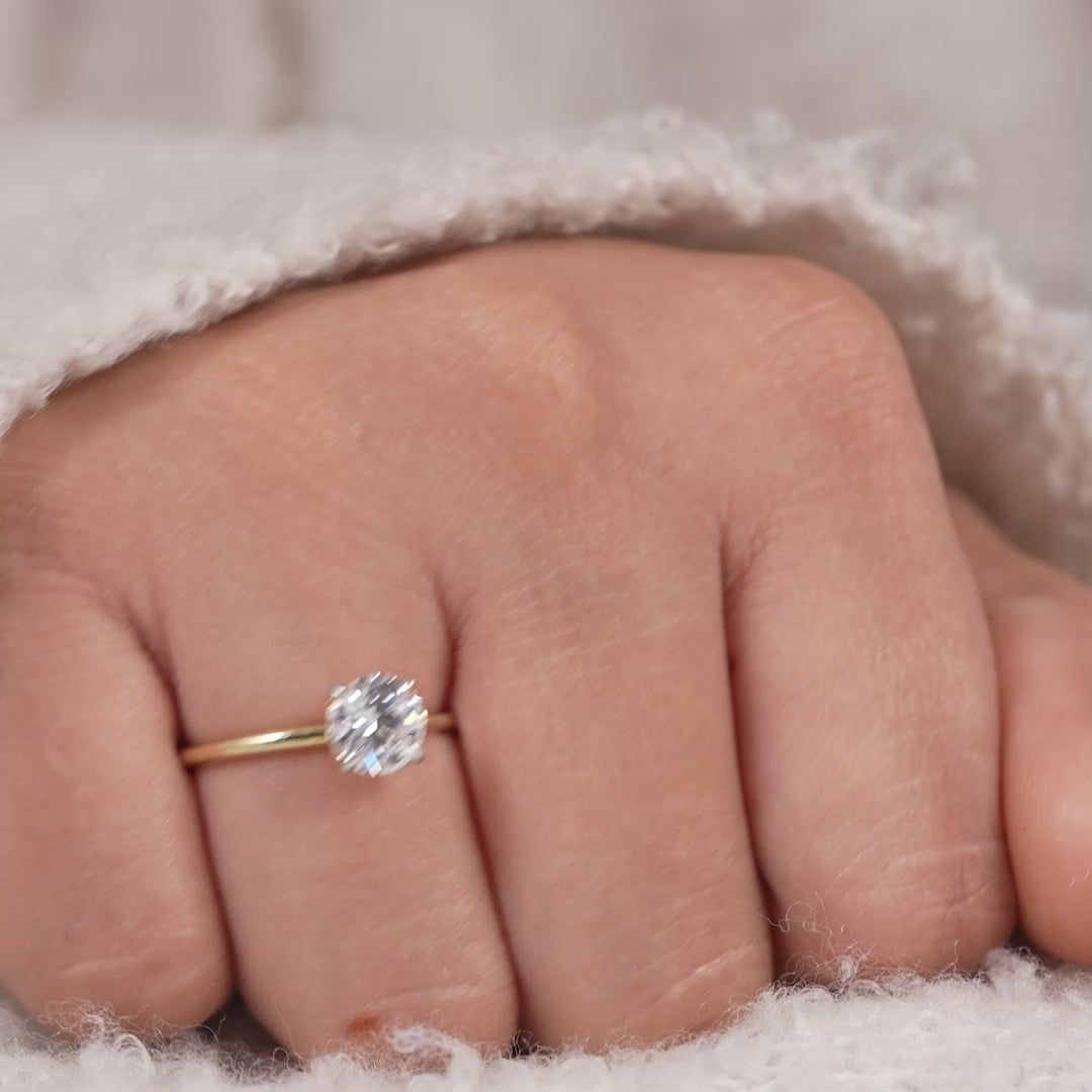 Minimalist round solitaire engagement ring with classic four prong setting