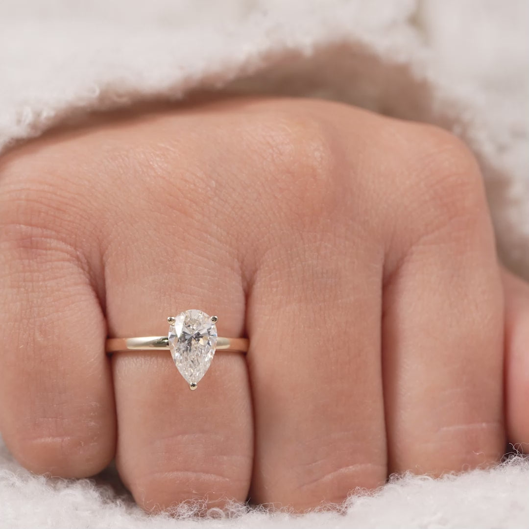 Pear shaped lab grown diamond solitaire ring with sleek gold band