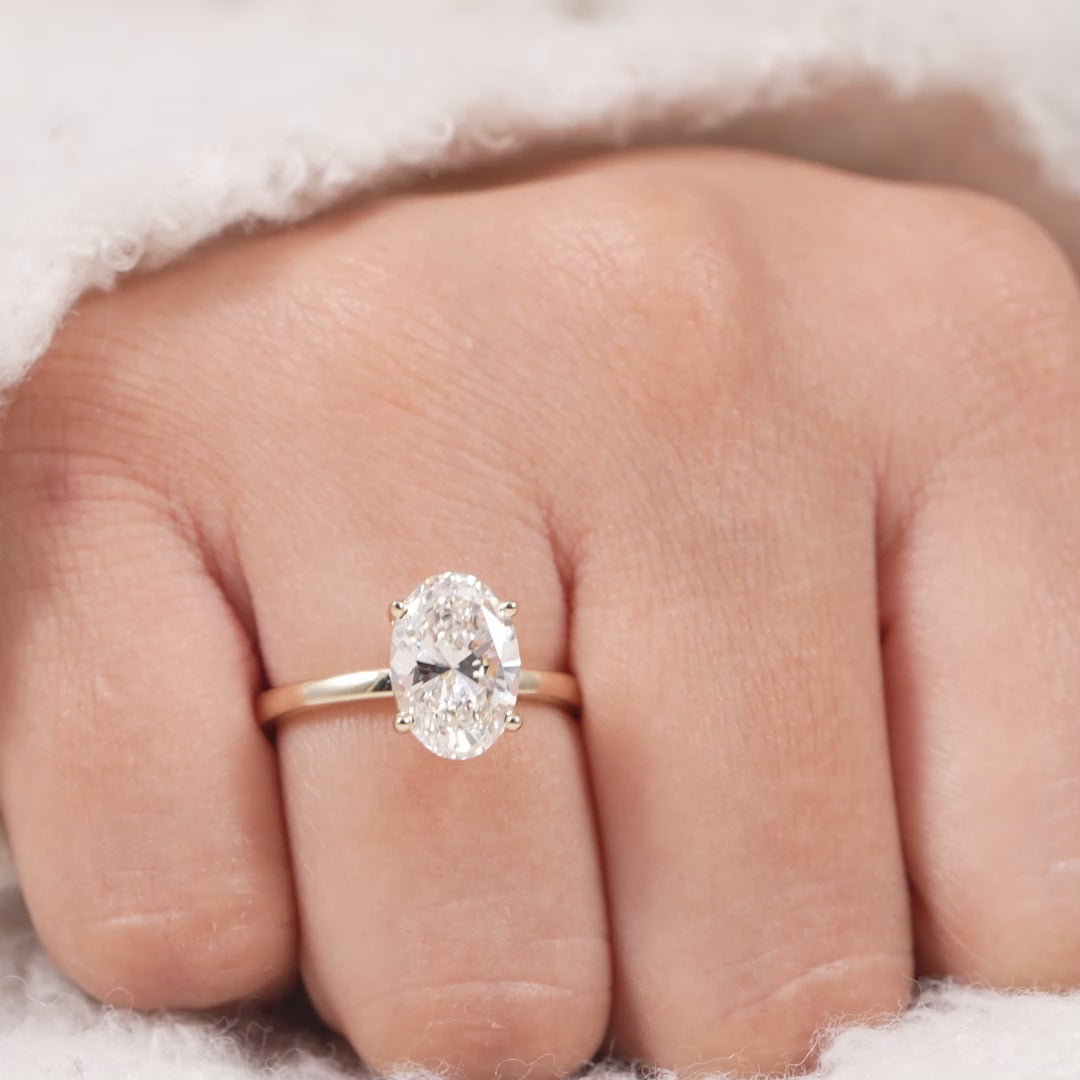 Oval solitaire lab grown diamond ring with elegant four prong gold band